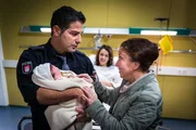 Tarik (Serhat Cokgezen, l.) freut sich über die Geburt seines und Paulines (Lucie Heinze, M.) Sohnes und präsentiert ihn stolz seiner Mutter (Lilay Huser, r.).