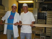 Willi (links) und der Bäckermeister Rolf in der Backstube, der ihm erklärt, wie das Brot gebacken wird.