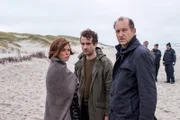 Hinnerk Feldmann (Oliver Wnuk, M.) und Carl Sievers (Peter Heinrich Brix, r.) müssen Ina Behrendsen (Julia Brendler, l.) beistehen, die gerade ihren Freund, den Robbenschützer Leo Fischer, tot am Strand gefunden hat.