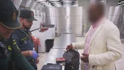 Ein Zollbeamter am Madrider Flughafen kontrolliert das Gepäck eines Passagiers