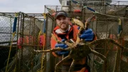 Deckhand Jon Farrel, Deckhand on the Cornelia Marie, holds up crab.