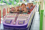 Stefan Vollmer (Hendrik Duryn, M.) sitzt mit Paula (Emily Lowin, r.) und Lea (Ella Päffgen, l.) in der Achterbahn.
