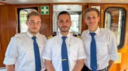 Die Hafenschiffer-Azubis Lasse Schütte (links) und Johann Reese (rechts) gehen mit Schiffsführer Ali Faour (Mitte) auf Übungsfahrt mit dem Alsterdampfer „Eilbek“.