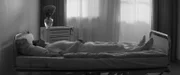 Die Krankenpflegerin (Amanda Babaei Vieira) liegt kraftlos in einem Pflegebett.