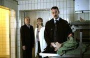 Die Gerichtsmediziner Dr. Kolmaar (Ulrich Mühe, l.) und Dr. Nadja Heron (Lavinia Wilson, M.) bitten Reinhardt Staufenfels (Heio von Stetten, r.), seine Frau zu identifizieren.