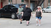 Chris (m.) walking with family outside apartment