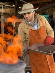 Ramy Romany stokes a fire for smelting