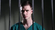Recre- Larry Ranes looking through jail cell bars.
