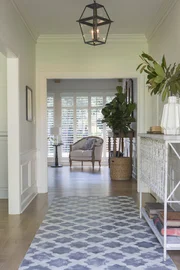 Durch einen helleren Anstrich und dem Fliesenakzent im Parkettboden wirkt der Eingangsbereich jetzt größer und einladender ...