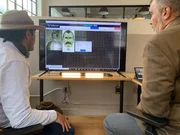 Ramy Romany (l.) and Roger Rodriguez (r.) look at computer screen with Facial recognition software
