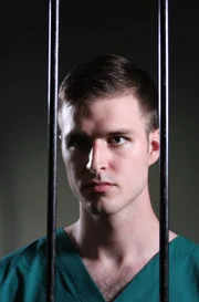 Larry Ranes looking through jail cell bars.