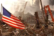 Eine US-amerikanische Flagge weht auf dem Trümmerfeld nach dem Einsturz beider Türme des World Trade Centers.