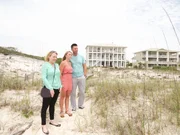 Realtor, Anita Elisar (L) and the homebuyers, Greg Hartwick (R) and his wife, Gena (C) checking out the beach near the first home.