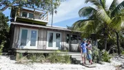 The homebuyers of the first home, Howard and Cyndy Livingston posing next to it.
