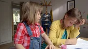 Elsa (Maya Anna Hansen Frølich) würde ihrer Schwester bei den Hausaufgaben gerne helfen.