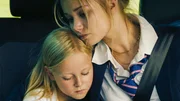 Nachdem ihre Mutter umgebracht wurde, sitzt Emmi Klettmann (Nele Richter, l.) mit ihrer Schwester Vivi Klettmann (Julia Beautx, r.) bedrückt im Auto. Sie werden von zu Hause weggebracht.