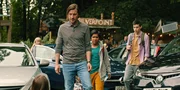 Meg (Katy Byrne, li.u.) hat sich in die Ausfahrt des Camps gesetzt, so dass kein Auto mehr durch kann. Hier will sie so lange sitzen bleiben, bis sie erfährt, wie es Kaz geht. Daniel (Liam McMahon), Glen (Krish Misra) und Louis (Oliver Cunliffe, von links) versuchen sie, zum Aufstehen zu bringen.
