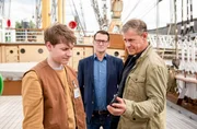 Finn (Sven Martinek, r.) und Lars (Ingo Naujoks, M.) konfrontieren Neeles Arbeitskollegen Timo (Filip Januchowski, l.) mit belastendem Videomaterial. Er war Neele und Pascal in der Tatnacht gefolgt.