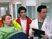 Der Fliesenleger Hans Lambert (Jürgen von der Lippe, links) wird nach einem Unfall vom Notarzt (Roman Petermann, Mitte) in die Sachsenklinik eingeliefert. Als Dr. Brentano (Thomas Koch) die beiden in Empfang nimmt, pfeift Hans Lambert schon wieder hübschen Patientinnen hinterher.