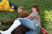 Während Brick (Atticus Shaffer, l.) noch mit seinem Essen ringt, ringen Marlene  (Mary Birdsong, r.) und Dr. Ted Goodwin (Jack McBrayer, m.) auf dem Rasen.