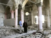 Spuren des Fanatismus: Daniel Gerlach (l.) mit einem Würdenträger (r.) der Syrisch-Orthodoxen Kirche in einem verwüsteten Gotteshaus im Nordirak.