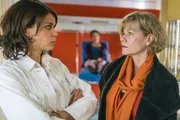 Karin (Anne Kasprik, r.) bittet Jasmin (Gerit Kling, l.) darum, die Behandlung von Eva Escobar hinauszuzögern, damit sie eine Möglichkeit hat, die Abschiebung der Frau zu verhindern.