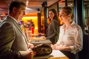 Hans (Bruno F. Apitz, l.) hat einen Tisch in dem Nobelrestaurant reserviert, in dem seine Tochter Nelly (Lisa Marie Fix, r.) arbeitet und überrascht sie. Er möchte seine Beförderung mit ihr und ihrer Mutter feiern. Nellys Chefin Greta (Julia Bremermann, M.) beobachtet die beiden skeptisch.