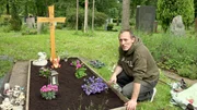 Florian widmet sich mit seiner ältesten Tochter Lea der Grabpflege.