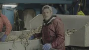 Deck Boss Nick McGlashan looks to camera after counting crab at the table on the Summer Bay.
