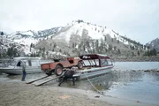 L-R:  Heinz Sippel, Buck Dewey, and Joni Dewey working to get jeep on the boat.