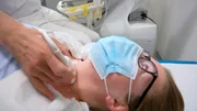 Der Arzt untersucht die Schilddrüse per Ultraschall.