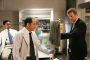 Unter den letzten Bewerbern herrscht große Unruhe. Cole (Edi Gathegi, l.) beobachtet, wie Dr. Taub (Peter Jacobson, M.) und House (Hugh Laurie) aneinander geraten.