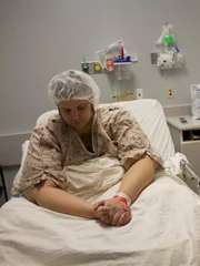 JT sits in hospital bed next to Dr Now