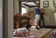 George choking Shauna in their home while their daughter watches nervously.