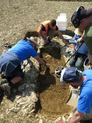 Menschen arbeiten an Ausgrabungen in einer archäologischen Stätte.