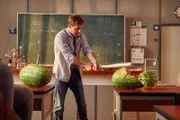 Stefan Vollmer (Hendrik Duryn) demonstriert mit Hilfe von Melonen den Einsatz von "Waffengewalt".
