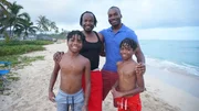 Home buyers Quintan Brassfield (R) and Cary Brassfield (L) on the beach with the kids as seen on Hawaii Hunters (portrait)