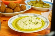 Stammgäste des beliebten Jerusalemer Hummus-Restaurants „Ikermawi“ essen zu ihrem Hummus oft Falafel und eingelegtes Gemüse. Stammgäste des beliebten Jerusalemer Hummus-Restaurants „Ikermawi“ essen zu ihrem Hummus oft Falafel und eingelegtes Gemüse.