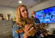 Mariana van Zeller in Allure's office holding a golden tiger statue.
