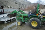 Buck Dewey on his old tractor, talking with his son Dax Dewey at Mackay Bar.