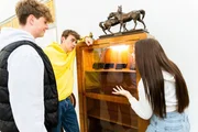 Acht Tage ohne Handy! Louis, Tim und Ashley stehen fassungslos vor einer Vitrine, in der ihre Handys aufbewahrt werden. Dort bleiben sie nun für acht Tage.