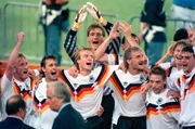 Die deutsche Mannschaft jubelt über über den Gewinn des Fußball-WM-Pokals am 08.07.1990 im Olympiastadion von Rom. V.l.n.r. Andreas Brehme, Pierre Littbarski, Jürgen Klinsmann, Bodo Illgner und Jürgen Kohler (beide Hintergrund), Rudi Völler, Thomas Häßler, Guido Buchwald und Thomas Berthold. Das deutsche Team bezwang im Finale die Argentinier mit 1:0.