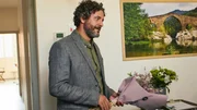 Inspector Castells (Isak Férriz) bringt Blumen ans Krankenbett von Alba, die mit einem Messer schwer verletzt wurde.