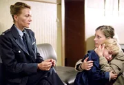 Baal (Karen Böhne, li.) erklärt Teresa (Nicole Ernst), dass sie sich jetzt von ihrem Sohn Olli (Paul Maximilian Schüller) verabschieden muss.