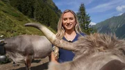 Moderatorin Iris Pohl vor Kuh mit Hörnern