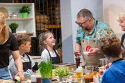 ZDFbesseresser Sebastian Lege mit Kindern und Betreuerinnen einer Dorstener Grundschule in seiner Küche