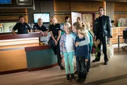 Franzi (Rhea Harder-Vennewald, vorne M.) freut sich, dass sie ihre Kinder Emma (Luna-Faye Wegener, vorne l.) und Felix (Fynn Staats, vorne r.) vom Dienst abholen. Sie hatte schon Angst, dass sie sie wegen ihrer neuen Nanny nicht vermissen würden (im Hintergrund: Bruno F. Apitz, l., Harald Maack, 2.v.l., Sanna Englund und Matthias Schloo, r.).