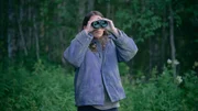 Kat (Eliot Sumner) beobachtet aus der Ferne einen Polizeieinsatz.