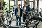 Die Kommissare Jonas Fischer (Jonas Piloty, r.) und Matti Wagner (Pierre Besson, l.) besuchen den Fahrradladen, in dem die tote Influencerin kurz vor ihrem Tod ein "Meet and Greet" veranstaltete.