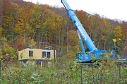 Die Arbeiten am Haus sind im vollen Gange: Wand für Wand wird mit dem Kran aufgesetzt.